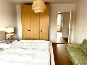 a bedroom with a bed and a couch and a lamp at Ferienwohnung Bärbel in Freyung