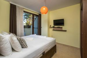 a bedroom with a bed with a tv on the wall at Апартамент Боров рай in Velingrad