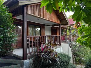 a house with a balcony with a door and some plants at PawPaw Resort in Lamai