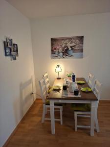 a dining room table with chairs and a lamp on it at Ferienwohnung Roessing 25194 in Bunde