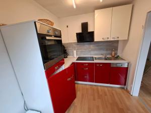 a kitchen with red cabinets and a red refrigerator at Ferienwohnung Roessing 25194 in Bunde