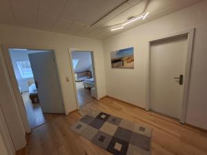 an empty room with two doors and a rug at Ferienwohnung Roessing 25194 in Bunde