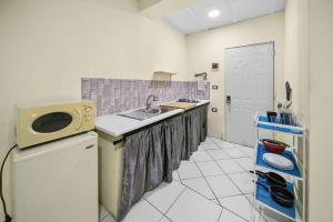 a kitchen with a sink and a refrigerator at Cheap Hotel Room in Sosua Center in Sosúa