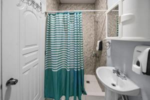 a bathroom with a shower curtain and a sink at Cheap Hotel Room in Sosua Center in Sosúa