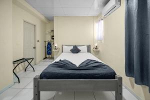a bedroom with a bed with a blue blanket on it at Cheap Hotel Room in Sosua Center in Sosúa