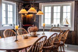 a dining room with a wooden table and chairs at Håholmen - by Classic Norway Hotels in Karvåg