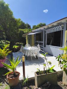 a patio with a table and chairs in front of a house at Gîte 1001 Nuits - SINBAD in Bouillante