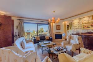 a living room with white chairs and a fireplace at Aerino House in Dassia