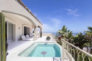 a villa with a swimming pool on a balcony at Luxury 8-Suite Villa with Heated Pools, Ocean & Mountain Views in Cape Town