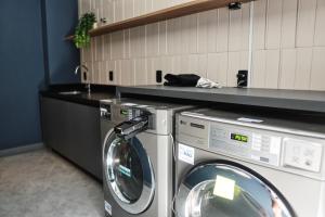 a laundry room with a washing machine and a sink at Xtay Oslo Florianópolis - Residential studio 5 minutes from downtown, close to Epic School and Atlantis Executive Center in Florianópolis