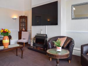 a living room with a leather couch and a stove at Drumford in Blackpool