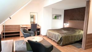 a bedroom with a bed and a desk and chairs at Arany Bárány Hotel in Zalaegerszeg +38 photos