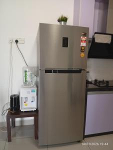 a stainless steel refrigerator in a kitchen next to a table at Seberang Jaya Family Pool Homestay Near Hospital 3 Bedroom Aircond 2 Bathroom & Family Room Aircond in Perai
