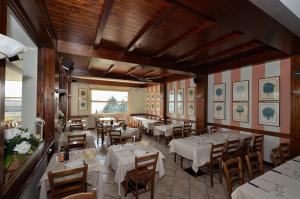 a dining room with white tables and chairs at Albergo Della Torre in Cernobbio