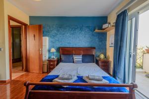 a bedroom with a bed with a blue wall at Aerino House in Dassia
