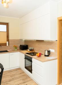 a kitchen with white cabinets and a stove top oven at Urocze Wysowa in Wysowa-Zdrój