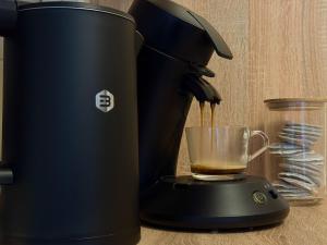 a black coffee maker with a cup of coffee at Charmant, Zentrumsnah, Natur in Augsburg