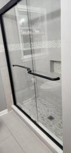 a glass shower door with a black handle in a bathroom at 3 Bedroom home near DC in Oxon Hill