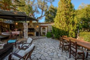 an outdoor patio with a wooden table and chairs at Aerino House in Dassia