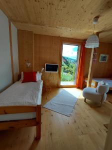 ein Schlafzimmer mit einem Bett und einem großen Fenster in der Unterkunft B&B Sunnesite Pratteln in Pratteln