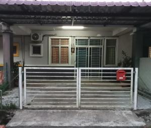 a house with a gate and stairs in front of it at Ayyash Cozy Homestay in Kuala Lipis