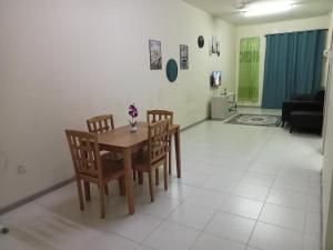 a dining room table and chairs in a living room at Ayyash Cozy Homestay in Kuala Lipis