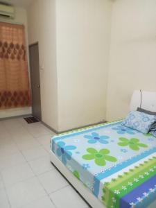 a room with a bed with a flower pattern on it at Ayyash Cozy Homestay in Kuala Lipis