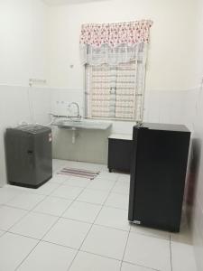 a bathroom with a tub and a sink and a window at Ayyash Cozy Homestay in Kuala Lipis