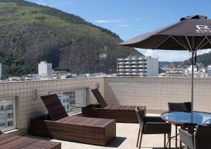 a patio with a table and chairs and an umbrella at Riale Vilamar Copacabana in Rio de Janeiro