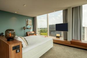 a bedroom with a large bed and a flat screen tv at Van der Valk Hotel Amsterdam Zuidas-Rai in Amsterdam