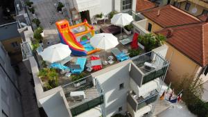 an overhead view of a pool with a slide and umbrellas at Hotel Orchidea Rimini in Rimini
