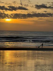 two people are walking on the beach at sunset at Tropical eglamping Mũi Né in Ấp Long Sơn +67 photos
