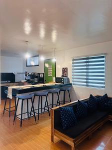 a living room with a bar with stools and a table at El Nido Homestay in El Nido