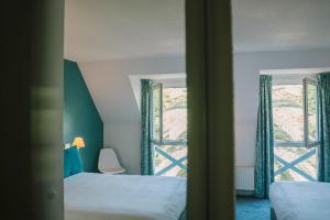 a bedroom with two beds and a window at Hotel Aigue Marine in Tréguier