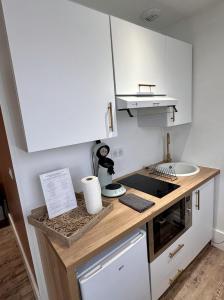 a kitchen with white cabinets and a counter top at Studio 1 des Remparts à 5 mins de Charleville-Mézières in Warcq