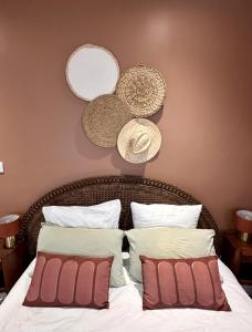 a bed with two pillows and two hats on the wall at Studio 1 des Remparts à 5 mins de Charleville-Mézières in Warcq