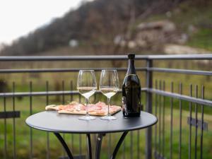 a table with two glasses and a bottle of wine at Lambo Cellini - Bed & Breakfast in Valdobbiadene +78 photos