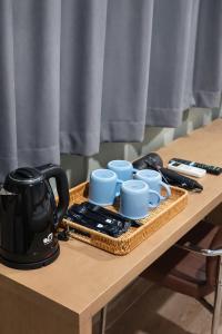 a table with a tray with cups and a tea kettle at Quicky Stay Airport in Min Buri