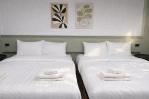 two beds with white towels on top of them at Quicky Stay Airport in Min Buri