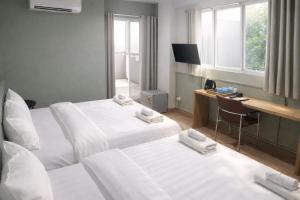 a hotel room with two beds and a desk at Quicky Stay Airport in Min Buri