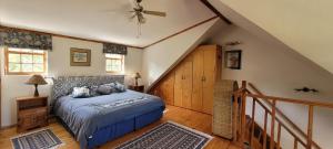 a bedroom with a bed and a staircase with a ceiling at Clarents Cottage in Somerset West +4 photos