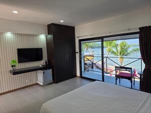 a bedroom with a bed and a view of the ocean at Samui Pier Beach Front & Resort in Bangrak Beach +40 photos