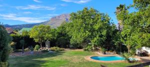 a yard with a swimming pool with a mountain in the background at Clarents Cottage in Somerset West
