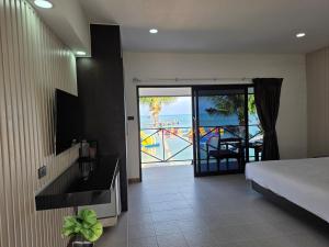 a bedroom with a bed and a view of the ocean at Samui Pier Beach Front & Resort in Bangrak Beach
