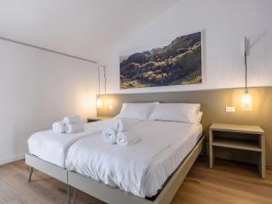 a bedroom with a large white bed with two towels on it at Lambo Cellini - Bed & Breakfast in Valdobbiadene