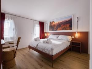 a bedroom with a large bed and a chair at Lambo Cellini - Bed & Breakfast in Valdobbiadene