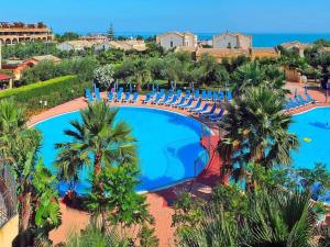 an aerial view of a resort pool with palm trees and chairs at Sweet Summer House in Campofelice di Roccella
