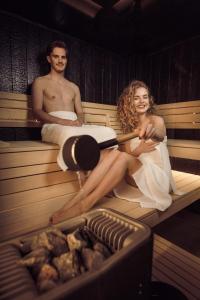 a man and a woman sitting in a sauna at Boutique Hotel Sunrose 7 - Gourmet & SPA in Bohinj