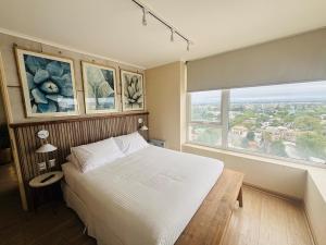 a bedroom with a large bed and a large window at Apart Hotel RCB in Chillán