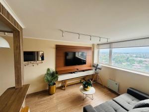 a living room with a couch and a television at Apart Hotel RCB in Chillán
